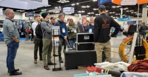 Travis Shirley talking to a crowd of visitors at The WWETT Show in Indianapolis, IN for trenchless pipe repair industry